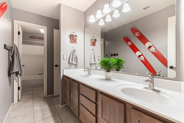 bathroom with tiled shower / bath combo, tile patterned floors, and vanity