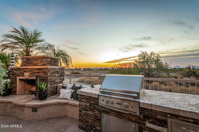 patio terrace at dusk featuring area for grilling