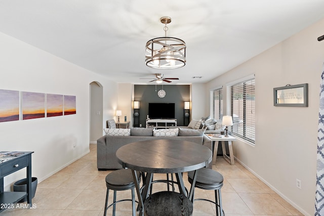 dining room with light tile patterned flooring and ceiling fan with notable chandelier