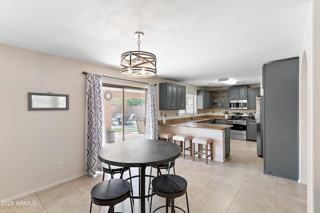 dining room featuring light tile patterned flooring, a chandelier, and sink