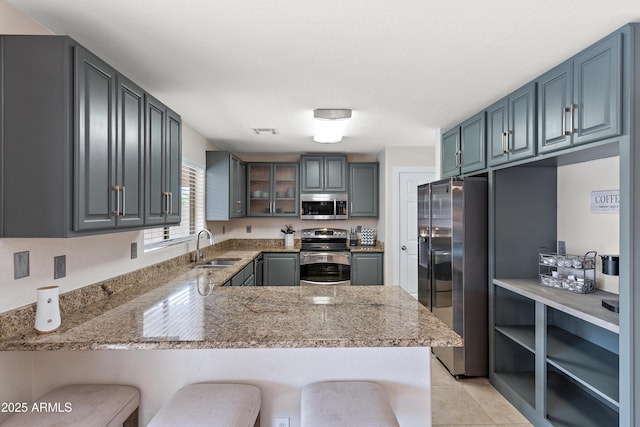 kitchen featuring stainless steel appliances, a breakfast bar, sink, and kitchen peninsula