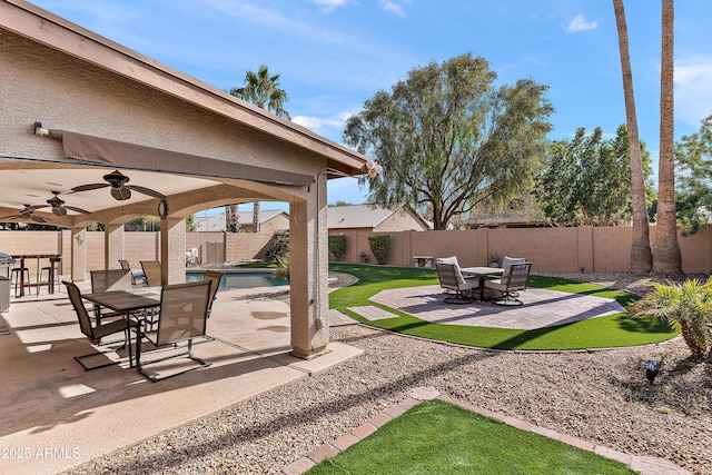 view of patio featuring a fenced in pool and ceiling fan