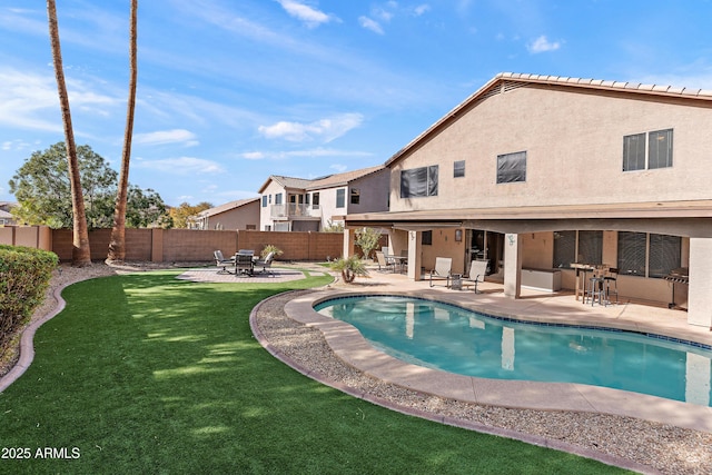 view of pool featuring an outdoor bar, a patio area, and a lawn