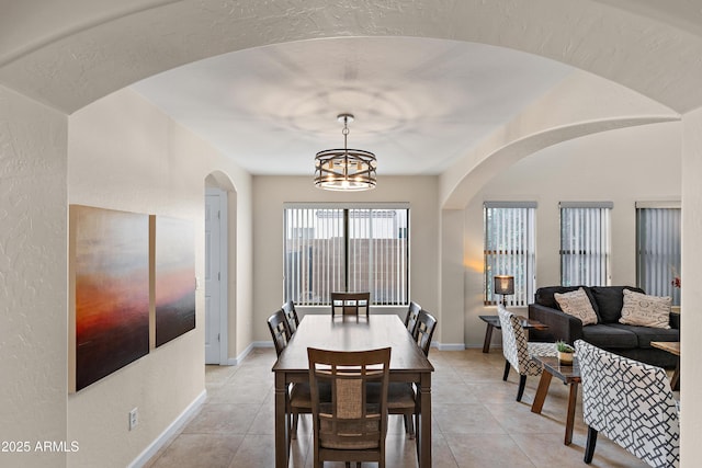 dining area with a chandelier and light tile patterned floors