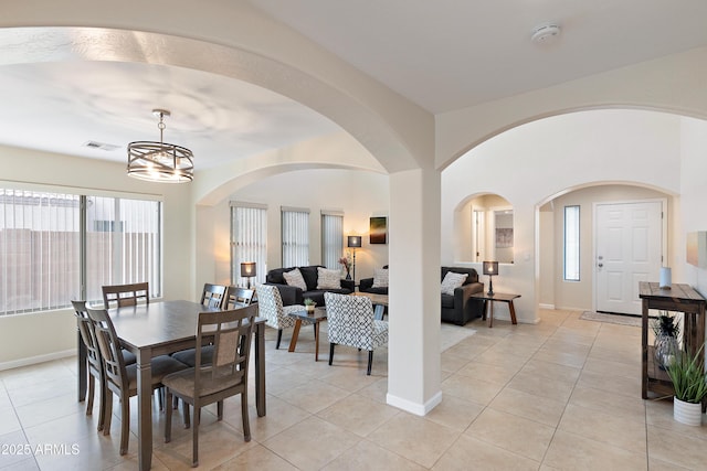 dining room with light tile patterned floors and a chandelier