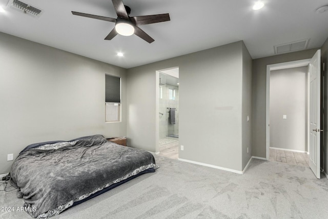 bedroom featuring light colored carpet, ceiling fan, and ensuite bathroom