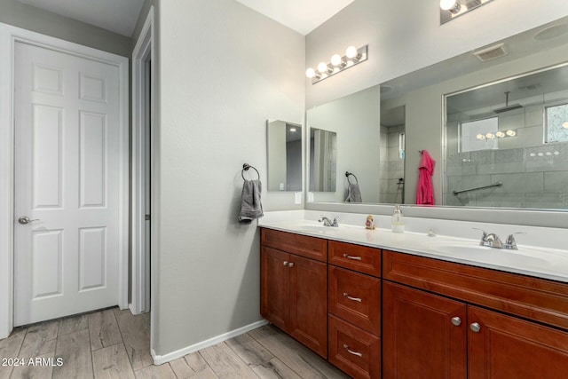 bathroom featuring hardwood / wood-style floors, vanity, and walk in shower