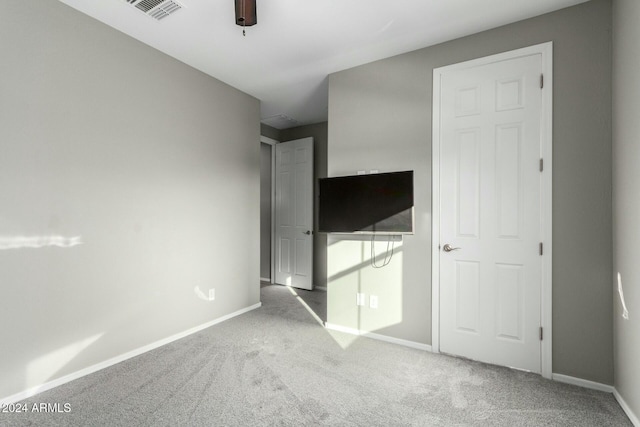 unfurnished bedroom with ceiling fan and carpet floors