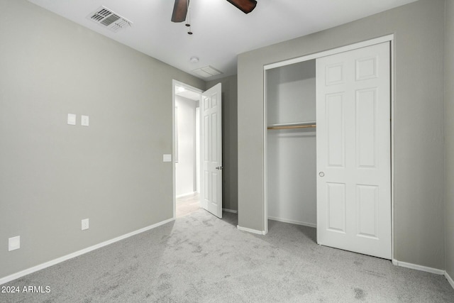 unfurnished bedroom featuring ceiling fan, light colored carpet, and a closet