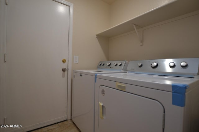 laundry area featuring washing machine and clothes dryer and light tile patterned flooring