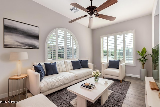 13448 W Miner Trl, Peoria, AZ 85383 - living room featuring healthy amount of natural light, a ceiling fan, baseboards, and light wood finished floors