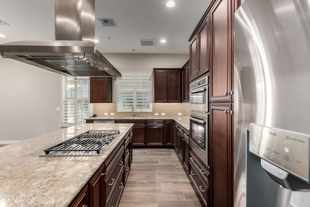 13448 W Miner Trl, Peoria, AZ 85383 - kitchen with appliances with stainless steel finishes, island exhaust hood, a sink, light stone counters, and recessed lighting