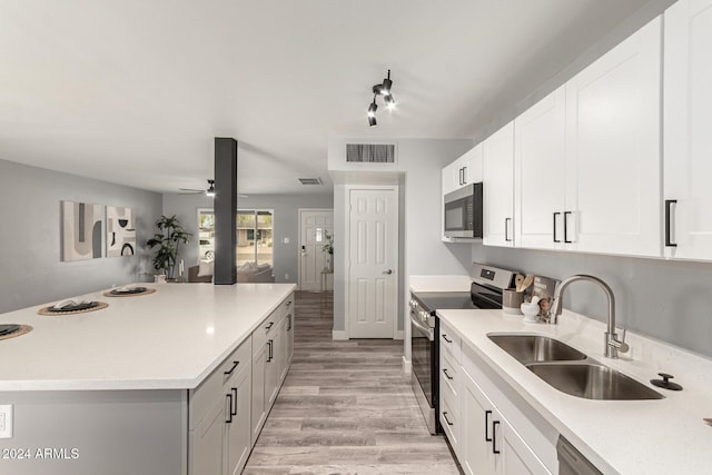 kitchen featuring white cabinetry, sink, light hardwood / wood-style flooring, and appliances with stainless steel finishes