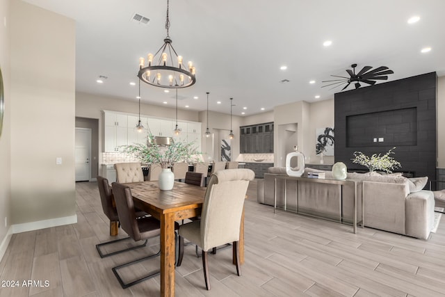 dining room with light hardwood / wood-style flooring and ceiling fan with notable chandelier