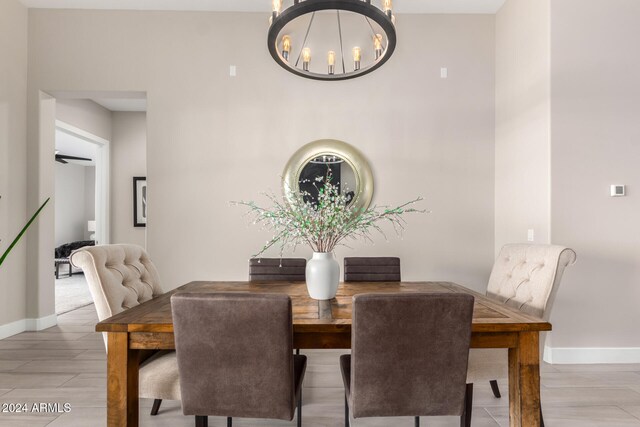 dining space featuring light hardwood / wood-style flooring and ceiling fan with notable chandelier