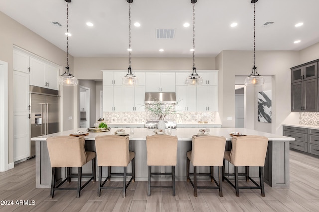 kitchen with a kitchen bar, a large island, and light wood-type flooring