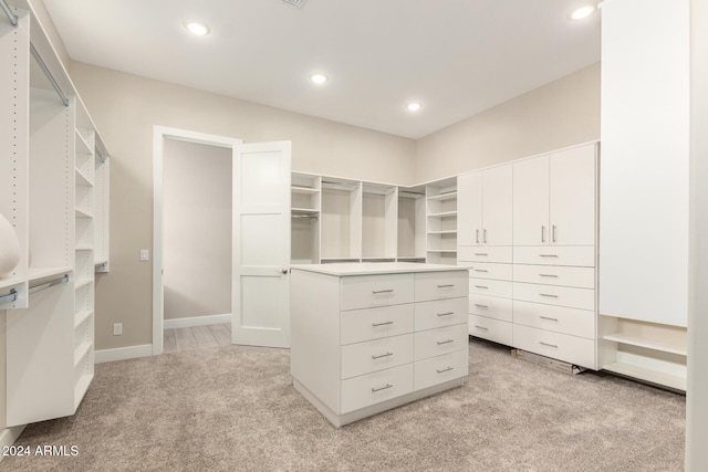 walk in closet featuring light colored carpet