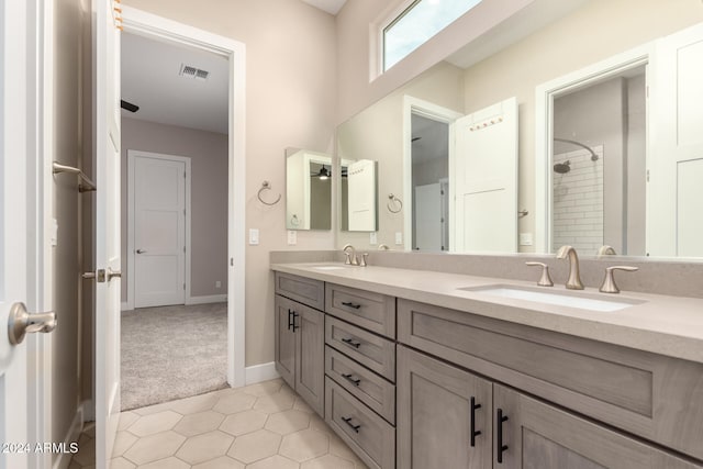 bathroom featuring tile patterned floors, vanity, and a tile shower