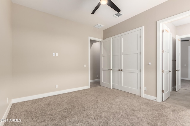 unfurnished bedroom with light carpet, a closet, and ceiling fan