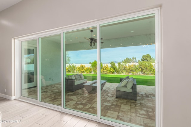 doorway with light hardwood / wood-style flooring, plenty of natural light, and ceiling fan