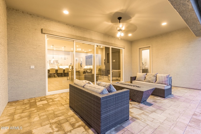 view of patio / terrace featuring ceiling fan and an outdoor living space with a fire pit