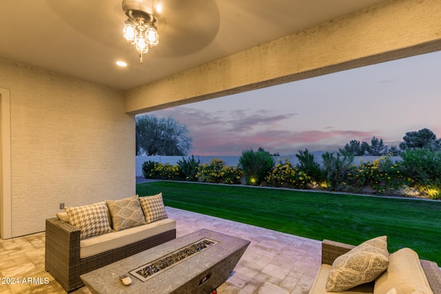 patio terrace at dusk featuring an outdoor living space and a yard