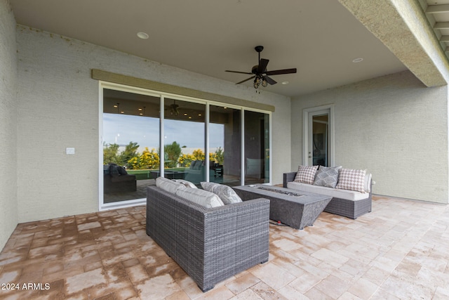 view of patio / terrace with ceiling fan and an outdoor living space with a fire pit