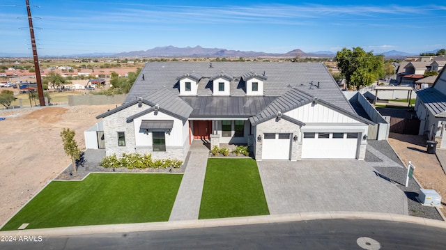 view of front facade with a mountain view, a front lawn, and a garage