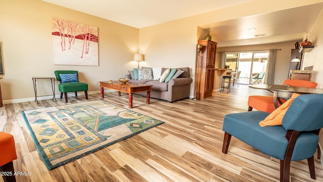 living room featuring visible vents, wood finished floors, and baseboards