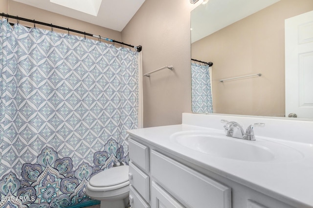 bathroom featuring vanity, toilet, and a skylight