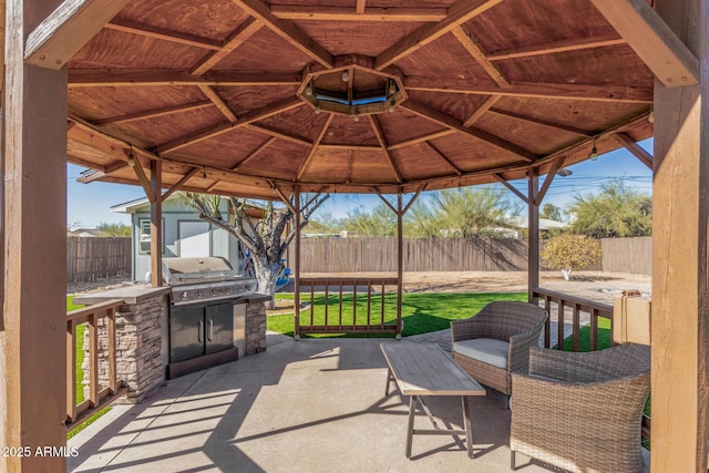 view of patio / terrace featuring a gazebo, an outdoor kitchen, a grill, and an outbuilding