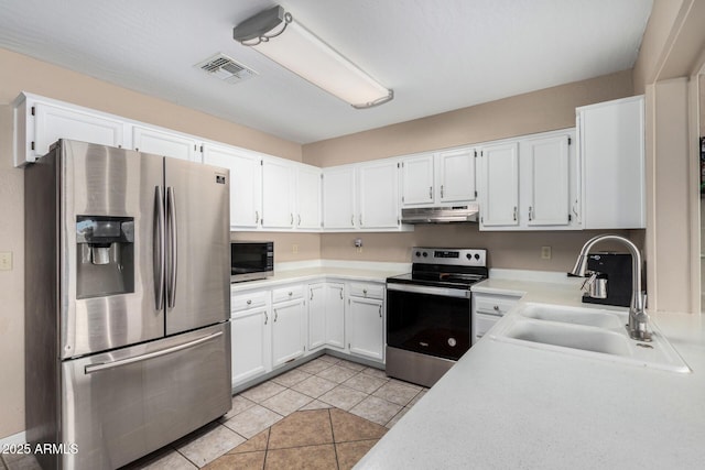 kitchen featuring light tile patterned floors, appliances with stainless steel finishes, sink, and white cabinets