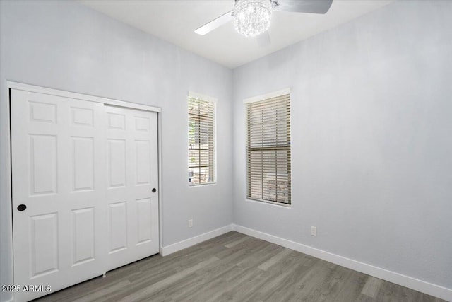 unfurnished bedroom with ceiling fan, a closet, and light hardwood / wood-style flooring