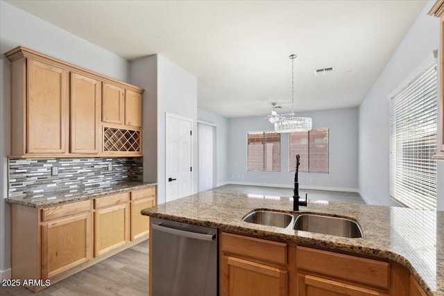 kitchen featuring sink, stainless steel dishwasher, backsplash, decorative light fixtures, and stone countertops