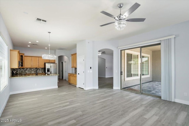 unfurnished living room with a wealth of natural light, light hardwood / wood-style floors, and ceiling fan