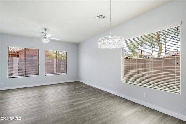 empty room featuring hardwood / wood-style floors and ceiling fan with notable chandelier