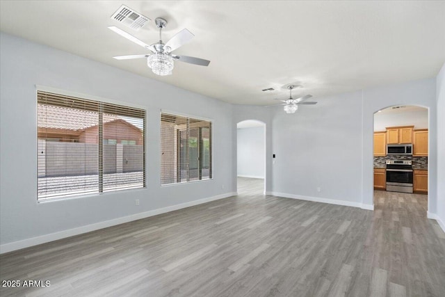 unfurnished living room featuring ceiling fan and light hardwood / wood-style flooring