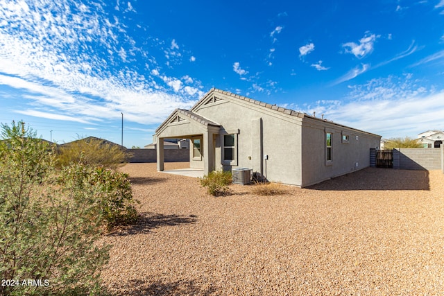 rear view of property with central air condition unit and a patio