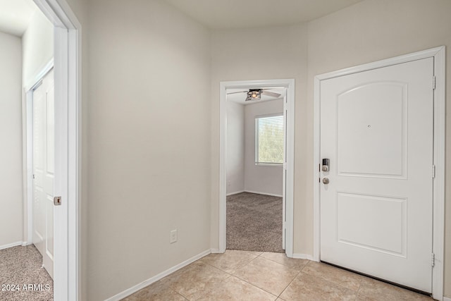 entrance foyer with ceiling fan and light colored carpet