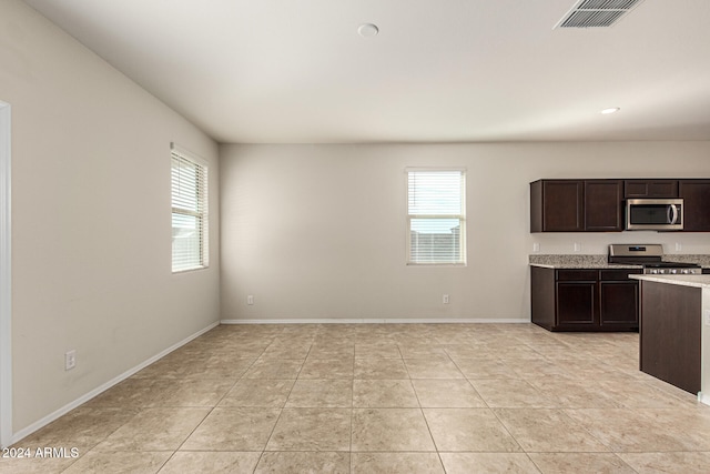 kitchen featuring appliances with stainless steel finishes, dark brown cabinets, and light tile patterned flooring