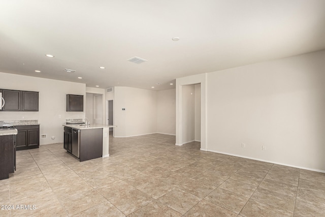 kitchen featuring dark brown cabinets, sink, and a center island with sink