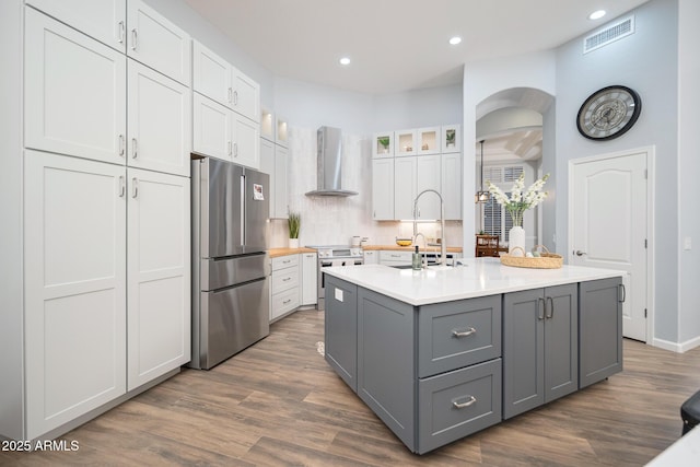 kitchen featuring white cabinetry, sink, stainless steel appliances, wall chimney range hood, and gray cabinets