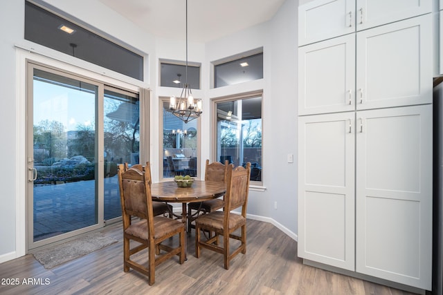 dining space featuring hardwood / wood-style floors and an inviting chandelier