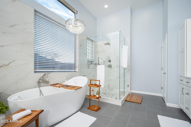 bathroom with tile patterned flooring, a notable chandelier, separate shower and tub, and a wealth of natural light