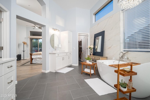 bathroom featuring a tub to relax in, tile patterned floors, plenty of natural light, and vanity