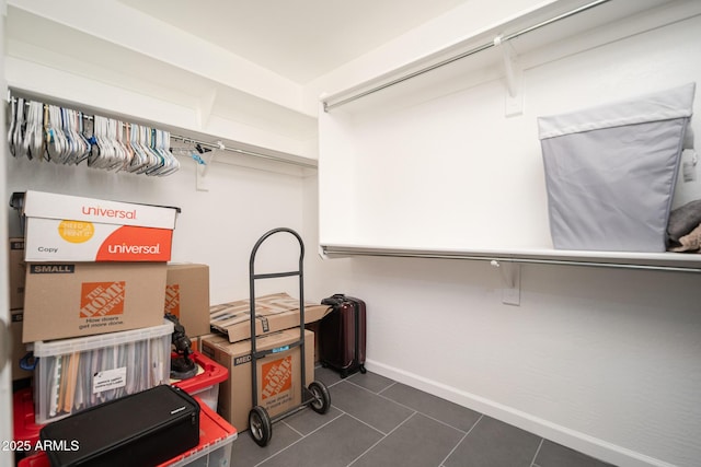 walk in closet featuring dark tile patterned flooring