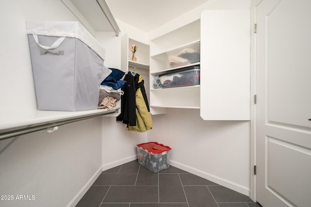 walk in closet with dark tile patterned flooring