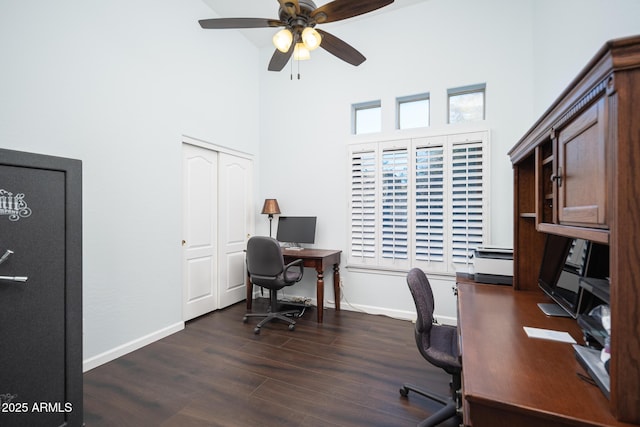 home office featuring a high ceiling, ceiling fan, and dark wood-type flooring