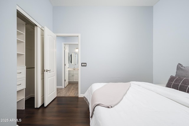 bedroom featuring a closet, dark wood-type flooring, and sink