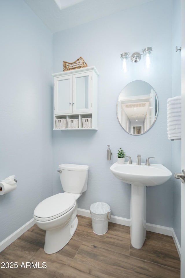 bathroom featuring wood-type flooring and toilet